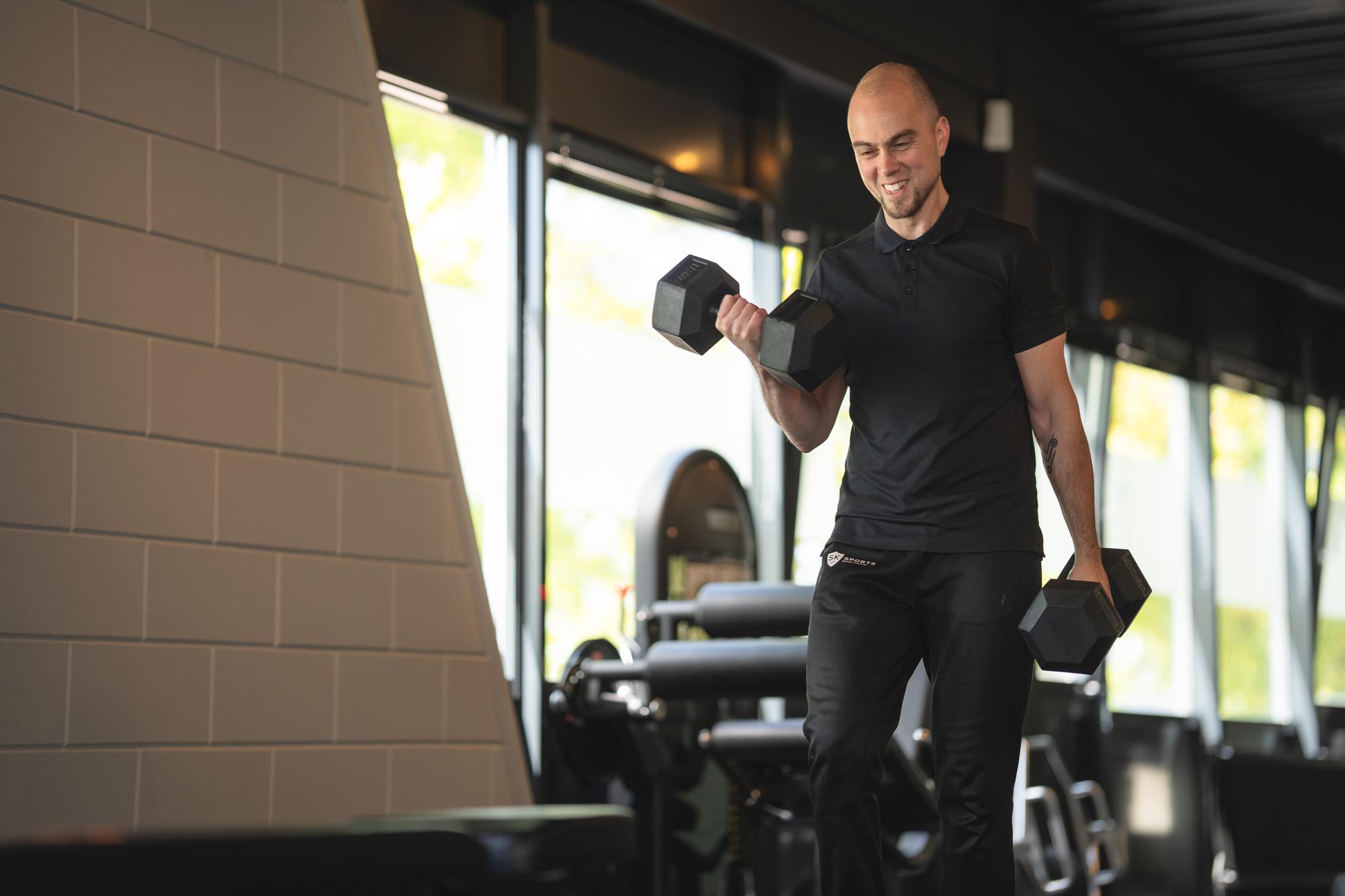Coach traint met dumbbells in de boutique